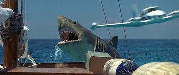 Movie still from “Jaws: The Revenge” (1987), directed by Joseph Sargent – A large shark with its mouth wide open on a boat in the ocean; Wide shot, Low angle