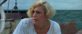 Movie still from “Jaws: The Revenge” (1987), directed by Joseph Sargent – A woman with blonde hair sitting in front of a body of water; Close Up shot, Low angle