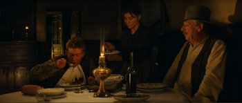 Movie still from “Jean de Florette” (1986), directed by Claude Berri – Two people sitting at a dinner table with plates and candles; Medium shot, High angle