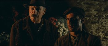 Movie still from “Jean de Florette” (1986), directed by Claude Berri – A man and a man with a hat on; Close Up shot, Over the shoulder angle