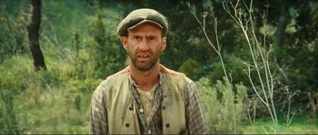 Movie still from “Jean de Florette” (1986), directed by Claude Berri – A man in a hat and vest standing next to a bush; Close Up shot, Low angle