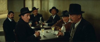 Movie still from “Jean de Florette” (1986), directed by Claude Berri – A group of men sitting at a table with drinks; Medium shot, Over the shoulder angle