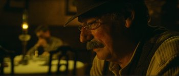 Movie still from “Jean de Florette” (1986), directed by Claude Berri – An older man wearing a hat and glasses; Close Up shot, Over the shoulder angle
