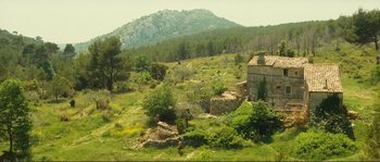 Movie still from “Jean de Florette” (1986), directed by Claude Berri – An old stone building in the middle of a green field; Extreme Wide shot, High angle