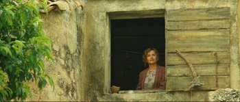 Movie still from “Jean de Florette” (1986), directed by Claude Berri – A woman looking out of an open window; Wide shot, Low angle