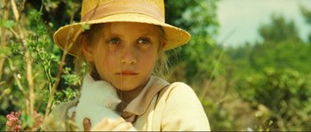 Movie still from “Jean de Florette” (1986), directed by Claude Berri – A young girl wearing a straw hat holding a white cat; Close Up shot, Low angle