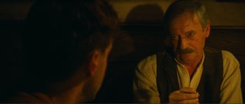 Movie still from “Jean de Florette” (1986), directed by Claude Berri – Two people are sitting in a dark room talking; Close Up shot, Over the shoulder angle