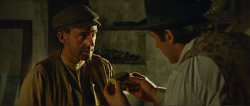 Movie still from “Jean de Florette” (1986), directed by Claude Berri – A man is looking at another man with a knife; Close Up shot, Over the shoulder angle