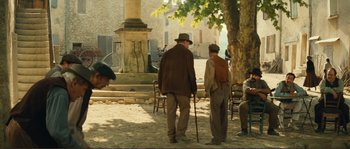 Movie still from “Jean de Florette” (1986), directed by Claude Berri – A group of men standing next to each other on a sidewalk; Wide shot, High angle