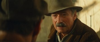 Movie still from “Jean de Florette” (1986), directed by Claude Berri – An older man wearing a cowboy hat looking at a younger man; Close Up shot, Over the shoulder angle