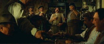Movie still from “Jean de Florette” (1986), directed by Claude Berri – A group of men standing around a table with drinks; Wide shot, Low angle