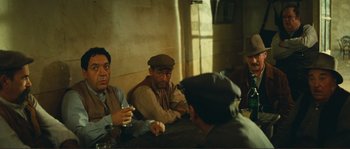 Movie still from “Jean de Florette” (1986), directed by Claude Berri – A group of men sitting at a table drinking; Medium shot, High angle