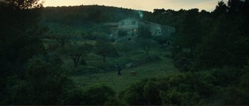 A man standing in a field near a building