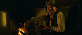 Movie still from “Jean de Florette” (1986), directed by Claude Berri – An old man sitting in front of an open fire; Medium shot, Over the shoulder angle