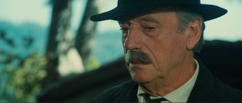 Movie still from “Jean de Florette” (1986), directed by Claude Berri – An older man with a mustache wearing a hat; Close Up shot, Over the shoulder angle