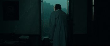 Movie still from “Jean de Florette” (1986), directed by Claude Berri – A man standing in front of an open window looking outside; Wide shot, Over the shoulder angle
