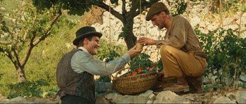 Movie still from “Jean de Florette” (1986), directed by Claude Berri – Two men sitting next to each other with a basket of fruit; Wide shot, High angle