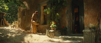 Movie still from “Jean de Florette” (1986), directed by Claude Berri – An old woman standing in front of a building; Wide shot, Low angle