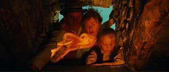 Movie still from “Jean de Florette” (1986), directed by Claude Berri – A man , woman , and a little girl are looking at a tablet; Medium shot, Low angle