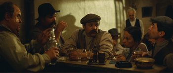 Movie still from “Jean de Florette” (1986), directed by Claude Berri – A group of men sitting at a table with drinks; Medium shot, High angle