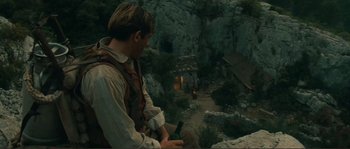 Movie still from “Jean de Florette” (1986), directed by Claude Berri – A man holding a wine bottle while standing on a cliff; Wide shot, High angle