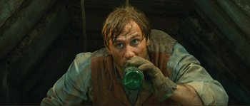Movie still from “Jean de Florette” (1986), directed by Claude Berri – A man drinking from a green glass bottle; Close Up shot, High angle