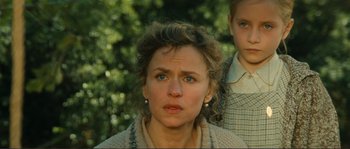 Movie still from “Jean de Florette” (1986), directed by Claude Berri – A woman and a boy standing next to each other in front of trees; Close Up shot, Low angle