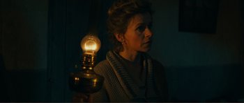 Movie still from “Jean de Florette” (1986), directed by Claude Berri – A woman standing next to an electric lamp; Close Up shot, High angle