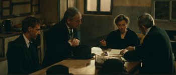 Movie still from “Jean de Florette” (1986), directed by Claude Berri – A man and a woman sitting at a wooden table; Medium shot, Over the shoulder angle