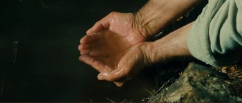 Movie still from “Jean de Florette” (1986), directed by Claude Berri – A person with their hands covered in oil; Extreme Close Up shot, High angle