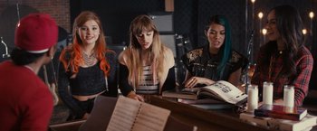 Movie still from “Jem and the Holograms” (2015), directed by Jon M. Chu – A group of young women sitting at a table; Medium shot, High angle