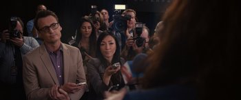 Movie still from “Jem and the Holograms” (2015), directed by Jon M. Chu – A group of people standing in a room with microphones; Medium shot, Over the shoulder angle