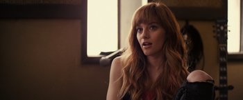 Movie still from “Jem and the Holograms” (2015), directed by Jon M. Chu – A beautiful young woman with long , red hair; Close Up shot, Over the shoulder angle
