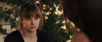 Movie still from “Jem and the Holograms” (2015), directed by Jon M. Chu – A woman sitting in front of another woman in front of a tree; Close Up shot, Over the shoulder angle