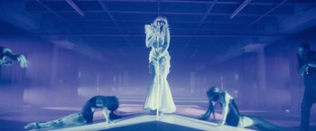 Movie still from “Jem and the Holograms” (2015), directed by Jon M. Chu – A woman standing on top of a pole in front of two dogs; Wide shot, Low angle