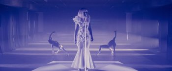 Movie still from “Jem and the Holograms” (2015), directed by Jon M. Chu – A woman in a white dress standing in front of two giraffes; Wide shot, Low angle