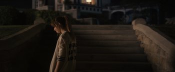 Movie still from “Jem and the Holograms” (2015), directed by Jon M. Chu – A girl is walking down the stairs at night; Medium shot, Over the shoulder angle