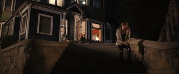 Movie still from “Jem and the Holograms” (2015), directed by Jon M. Chu – A woman sitting on the steps outside of a house at night; Wide shot, High angle