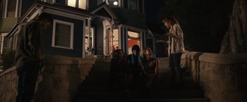Movie still from “Jem and the Holograms” (2015), directed by Jon M. Chu – A group of people sitting on the steps of a house; Wide shot, Over the shoulder angle