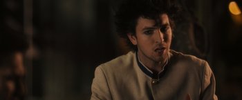 Movie still from “Jem and the Holograms” (2015), directed by Jon M. Chu – A young man with spiky black hair and a white jacket; Close Up shot, Over the shoulder angle