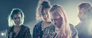 Movie still from “Jem and the Holograms” (2015), directed by Jon M. Chu – Two young women with long pink hair standing next to each other; Close Up shot, High angle