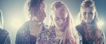 Movie still from “Jem and the Holograms” (2015), directed by Jon M. Chu – A woman with long pink hair is looking down; Close Up shot, Low angle