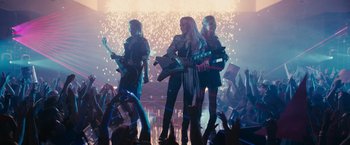 Movie still from “Jem and the Holograms” (2015), directed by Jon M. Chu – A group of people that are standing in a room; Wide shot, Low angle