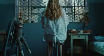 Movie still from “Jennifer's Body” (2009), directed by Karyn Kusama – A woman sitting at a desk in a room; Medium shot, High angle