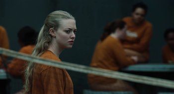Movie still from “Jennifer's Body” (2009), directed by Karyn Kusama – A woman in an orange prison uniform looking to her left; Close Up shot, Over the shoulder angle