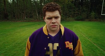 Movie still from “Jennifer's Body” (2009), directed by Karyn Kusama – A man in a purple and yellow jacket standing in a field; Close Up shot, Low angle