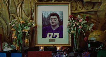 Movie still from “Jennifer's Body” (2009), directed by Karyn Kusama – A picture of a young football player in a frame; Medium shot, Low angle