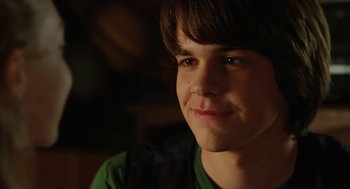 Movie still from “Jennifer's Body” (2009), directed by Karyn Kusama – A young man smiling for the camera; Close Up shot, Over the shoulder angle
