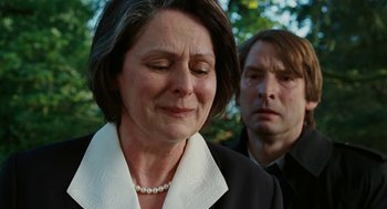 Movie still from “Jennifer's Body” (2009), directed by Karyn Kusama – An older woman and a younger man standing next to each other in front of trees; Close Up shot, Over the shoulder angle