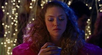 Movie still from “Jennifer's Body” (2009), directed by Karyn Kusama – A woman with long curly hair is holding a cell phone; Close Up shot, Over the shoulder angle